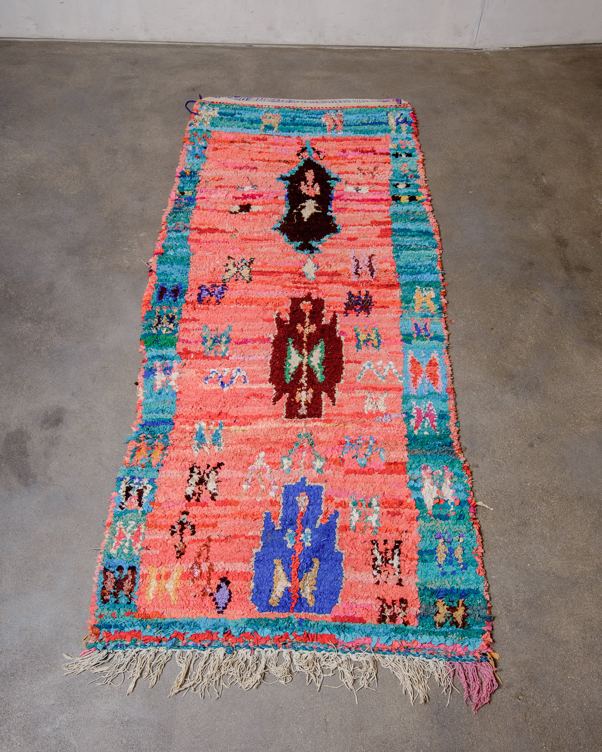 Berberlin vintage Boucherouite runner rug laying flat on concrete floor.
